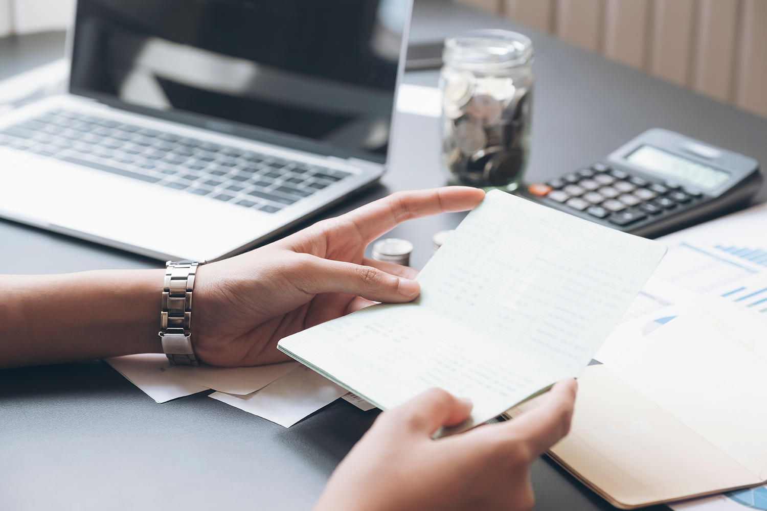 Accountant hands holding saving account passbook, book bank. Business account saving concept.